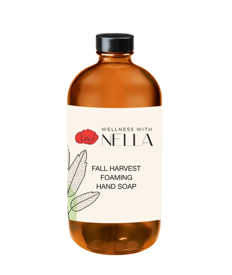The image shows a bottle of "Fall Harvest Foaming Hand Soap" from "Wellness with Nella." The bottle is amber with a simple, elegant label.